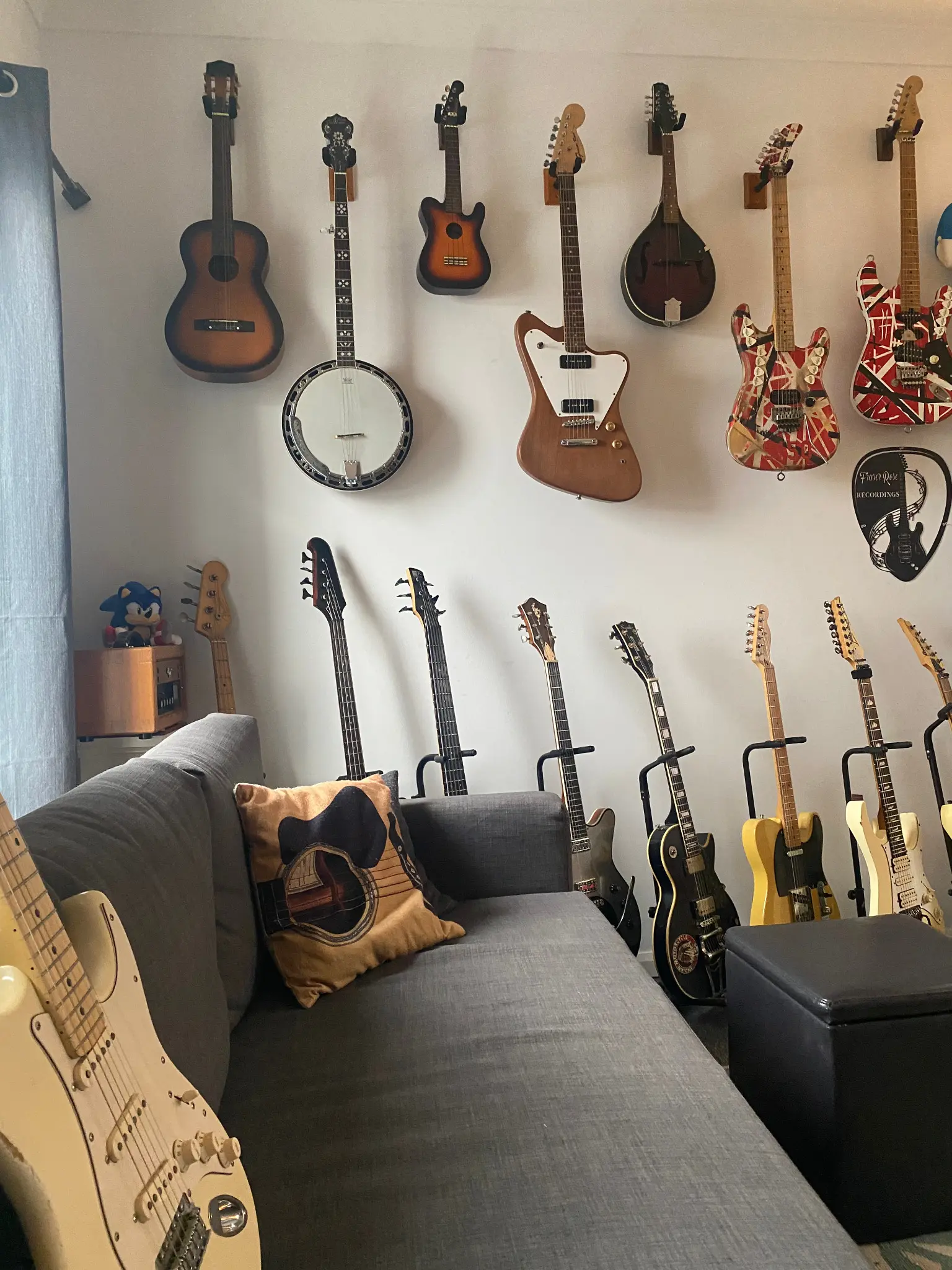 A comfortable studio seating area surrounded by guitars and other instruments